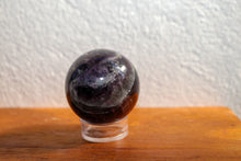 Load image into Gallery viewer, Dark coloured small sized polished Fluorite sphere with deep purple shades, on stand (not included)
