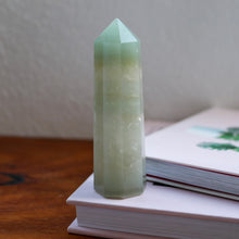 Load image into Gallery viewer, Light Green Aventurine Tower (point) sitting atop a book
