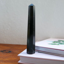 Load image into Gallery viewer, Tall Slender Black Tourmaline Tower sitting atop a book
