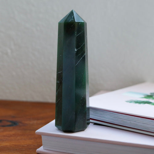 Deep Emerald Green Aventurine Tower (point) sitting atop a book