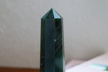 Load image into Gallery viewer, Close up of Deep Emerald Green Aventurine Tower (point) sitting atop a book
