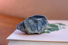 Load image into Gallery viewer, Singular Deep Blue Kyanite Cluster, Hand sized with yellow and brown inclusions, sitting on top of two books
