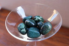 Load image into Gallery viewer, Birds eye view - A handful of Moss Agate tumbles, beautiful shades of deep forest greens, held in a clear martini glass
